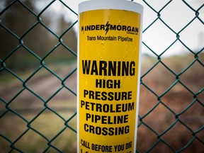 A sign warning of an underground petroleum pipeline is seen on a fence at Kinder Morgan's facility.