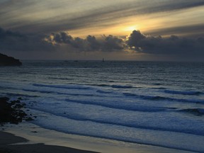 The sun sets over the sea looking towards Lands End viewed from Gwenver beach near Sennen Cove on February 7, 2011 in Cornwall, England.