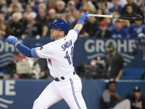 Justin Smoak #14 of the Toronto Blue Jays hits a double in the first inning during MLB game action against the New York Yankees at Rogers Centre on March 30, 2018 in Toronto.