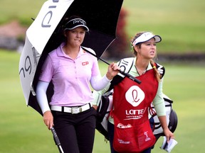 Brooke Henderson of Canada and her caddie Brittany Henderson make their way to the 18th green as a light rain falls during the second round of the LPGA LOTTE Championship at the Ko Olina Golf Club in Kapolei, Hawaii on April 12, 2018.