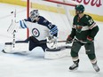 Winnipeg Jets goaltender Connor Hellebuyck makes a stick save as Matt Dumba #24 of the Wild looks on during the third period of Game 4 of their Western Conference first round playoff series on Tuesday night at Xcel Energy Center in St Paul, Minn. The Jets won 2-0.