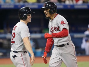 Mookie Betts of the Boston Red Sox is congratulated by Brock Holt after hitting a solo home run in the seventh inning against the Blue Jays at Rogers Centre in Toronto on Wednesday night.