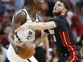 Miami Heat guard Tyler Johnson (8) attempts to swat the ball away from Brooklyn Nets guard Caris LeVert (22) during the first half of an NBA basketball game, Saturday, March 31, 2018, in Miami.