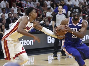 Philadelphia 76ers' Joel Embiid,, right, drives to the basket as Miami Heat's Hassan Whiteside, left, defends during the first half of Game 3 of a first-round NBA basketball playoff series Thursday, April 19, 2018, in Miami.