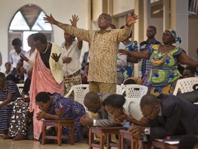 FILE - In this Sunday, April 6, 2014 file photo, Rwandans sing and pray at the Evangelical Restoration Church in the Kimisagara neighbourhood of the capital Kigali, Rwanda. Rwanda's government in 2018 is closing thousands of churches and dozens of mosques as it seeks to assert more control over a vibrant religious community whose sometimes makeshift operations, authorities say, have threatened the lives of followers.