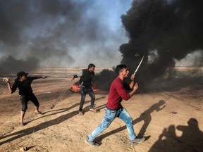 Palestinian protesters demonstrate during clashes with Israeli security forces near the border with Israel, east of Khan Yunis, in the southern Gaza Strip, on April 01, 2018.