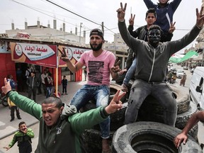 Palestinian men sit in a trailer loaded with tyres in Rafah, in the southern Gaza Strip, on April 5, 2018, as a tent protest continues in support of Palestinian refugees returning to lands they fled or were expelled from during the 1948 war surrounding Israel's creation.