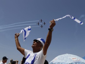 Israelis watch an air show during the festivities of the 70th Independence Day, on April 19, 2018 in the Mediterranean coastal city of Tel Aviv. Israel marks 70 years since the founding of the country according to the Hebrew calendar, celebrated as Independence Day and a national holiday.