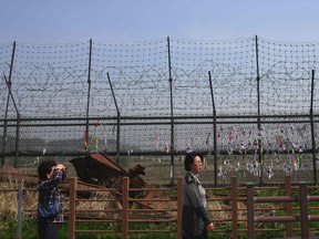 Visitors walk past a military fence at Imjingak peace park in Paju near the demilitarized zone dividing the two Koreas on April 26, 2018 ahead of the upcoming inter-Korea summit.