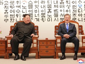 This picture taken on April 27, 2018 and released from North Korea's official Korean Central News Agency (KCNA) on April 29, 2018 shows  North Korea's leader Kim Jong Un (L) talking with South Korea's President Moon Jae-in (R) before the inter-Korean summit at the Peace House building on the southern side of the truce village of Panmunjom.