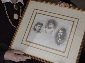Marla Andrews holds a photograph of her father Tuskegee Airman Capt. Lawrence E. Dickson, back row, third from left.