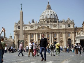 Juan Carlos Cruz, center, walks past St.Peter's Basilica as he arrives for an interview with The Associated Press, in Rome, Tuesday, April 24, 2018. Cruz, who is the key whistleblower in Chile's clerical sex abuse scandal, has arrived in Rome for his audience with Pope Francis and says he will urge Francis to get rid of the "toxic" bishops and cardinals who have defamed and discredited him and other abuse survivors around the world.