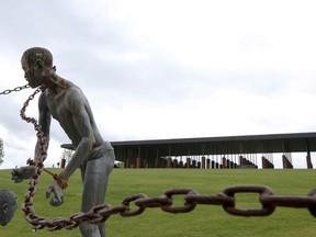 A statue of a chained man is on display at the National Memorial for Peace and Justice, a new memorial to honor thousands of people killed in racist lynchings, Sunday, April 22, 2018, in Montgomery, Ala. The national memorial aims to teach about America's past in hope of promoting understanding and healing. It's scheduled to open on Thursday.