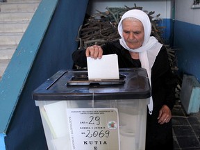 An Albanian woman casts her vote at a polling station in the village of Fushas, near Tirana, in a file photo from June 23, 2013.