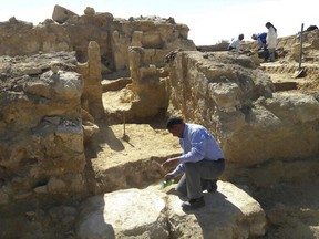 This undated photo released by the Egyptian Ministry of Antiquities shows archeologists working at the site of the remains of a temple dating back to the Greco-Roman period in the country's western desert, some 31 miles, 50 km, west of Siwa Oasis, Egypt. The ministry said the uncovered part include stone walls and the temple's main entrance which leads to courtyard and entrances to other chambers. (Egyptian Ministry of Antiquities via AP)