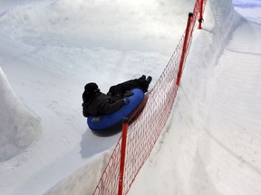 In this March 9, 2018 photo, a woman slides as she visits the "Snow City" in the Al-Othaim Mall, in Riyadh, Saudi Arabia.