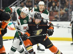 Minnesota Wild left wing Jordan Greenway, left, and Anaheim Ducks right wing Ondrej Kase, of the Czech Republic, vie for the puck during the first period of an NHL hockey game Wednesday, April 4, 2018, in Anaheim, Calif.