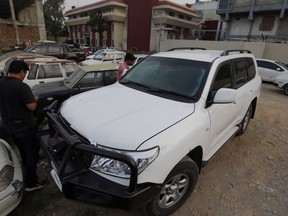 Pakistani journalists examine a car of American diplomate parked inside a police station after an accident in Islamabad, Pakistan, Saturday, April 7, 2018. Pakistani police say a car carrying an American diplomat has accidentally hit a Pakistani motorcyclist in the capital, Islamabad, killing him on the spot.