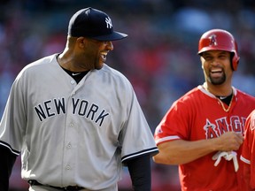 New York Yankees starting pitcher CC Sabathia, left, and Los Angeles Angels' Albert Pujols laugh after Pujols grounded out to Sabathia during the first inning of a baseball game Sunday, April 29, 2018, in Anaheim, Calif.