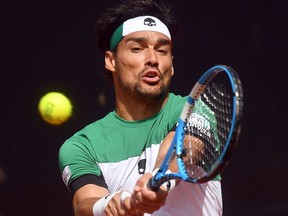 Italy's Fabio Fognini returns the ball to France's Lucas Pouille during a World Group Quarter final Davis Cup tennis match between Italy and France in Genoa, Italy, Sunday April 8, 2018.