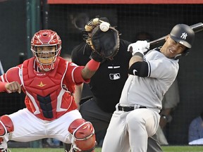 New York Yankees' Gleyber Torres, right, avoids a close pitch as Los Angeles Angels catcher Martin Maldonado catches during the second inning of a baseball game Sunday, Dec. 31, 2017, in Anaheim, Calif.