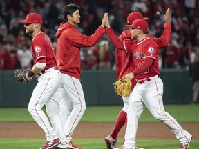 Los Angeles Angels' Shohei Ohtani, center, celebrates the team's 13-9 win over the Oakland Athletics with his teammates at the end of the baseball game, Friday, April 6, 2018, in Anaheim, Calif.