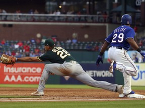 Oakland Athletics first baseman Matt Olson (28) reaches out for the throw as Texas Rangers' Adrian Beltre (29) reaches on a single to second in the second inning of a baseball game Tuesday, April 24, 2018, in Arlington, Texas.