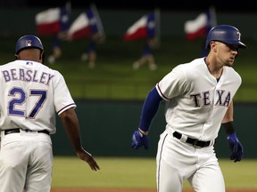 Texas Rangers third base coach Tony Beasley (27) congratulates Ryan Rua, right, on his solo home run in the third inning of a baseball game against the Los Angeles Angels in Arlington, Texas, Wednesday April 11, 2018.
