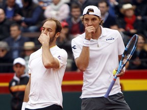 Germans Jan-Lennard Struff, Tim Puetz talk during their match against Spanish Marc Lopez and Feliciano during a World Group Quarter final Davis Cup tennis match at the bullring in Valencia, Spain, Saturday, April 7, 2018.