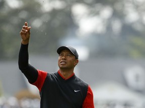 Tiger Woods tests the wind on the first hole during the fourth round at the Masters golf tournament Sunday, April 8, 2018, in Augusta, Ga.