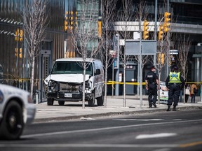 Police are seen near a damaged van in Toronto after a van mounted a sidewalk crashing into a number of pedestrians on Monday, April 23, 2018.