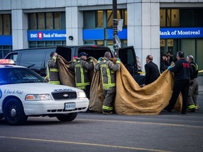 A coroner removes a dead body from the sidewalk after a van hit a number of pedestrians on Yonge Street and Finch in Toronto on Monday, April 23, 2018. Ten people died and 15 others were injured when a van mounted a sidewalk and struck multiple pedestrians along a stretch of one of Toronto's busiest streets.