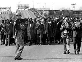 FILE - In this March 10, 1965 file photo, demonstrators, including Dr. Martin Luther King, Jr., stream over an Alabama River bridge at the city limits of Selma, Ala., during a voter rights march. King's participation in the 54-mile (87-kilometer) march from Selma, Ala., to the state capital of Montgomery elevated awareness about the troubles blacks faced in registering to vote. (AP Photo/File)