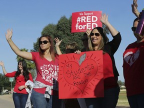 Teachers from Highland Arts Elementary School stage a final walk-in Wednesday, April 25, 2018, in Mesa, Ariz. Communities and school districts are preparing for a historic statewide teacher walkout on Thursday that could keep hundreds of thousands of students out of school indefinitely.