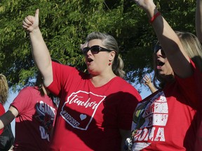 Highland Arts Elementary School sixth grade teacher Meredith Hey gives a thumbs-up during a final walk-in Wednesday, April 25, 2018, in Mesa, Ariz. Communities and school districts are preparing for a historic statewide teacher walkout on Thursday that could keep hundreds of thousands of students out of school indefinitely.