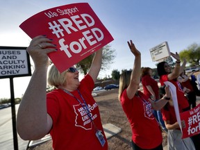 Teachers at Humphrey Elementary school participate in a state-wide walk-in prior to classes Wednesday, April 11, 2018, in Chandler, Ariz. Arizona teachers are demanding a 20 percent pay raise and more than $1 billion in new education funding.
