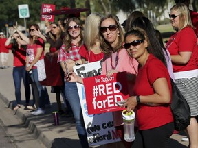 Teachers from Highland Arts Elementary School stage a final walk-in Wednesday, April 25, 2018, in Mesa, Ariz. Communities and school districts are preparing for a historic statewide teacher walkout on Thursday that could keep hundreds of thousands of students out of school indefinitely.