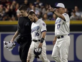 Arizona Diamondbacks manager Torey Lovullo (17) signals for a replacement during the third inning of a baseball game Thursday, April 19, 2018, in Phoenix as Chris Owings (16) leaves the game after catching a fly out hit by San Francisco Giants' Joe Panik. Owings collided with teammate A.J. Pollock after the catch.