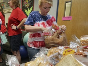 Highland Arts Elementary School teacher Melanie Inigues organizes donated food for distribution to students and families on the eve of the teacher walk out Wednesday, April 25, 2018, in Mesa, Ariz.