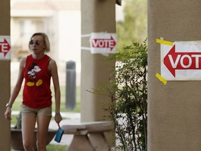 A voter leaves a polling station after casting a vote as Democratic candidate Dr. Hiral Tipirneni and Republican Debbie Lesko look to fill the CD8 seat vacated by Republican Rep. Trent Franks in a special election, Tuesday, April 24, 2018, in Glendale, Ariz.