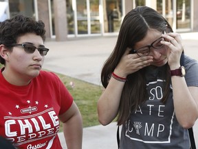 Darian Cruz, right, wipes away tears as she and Jasmin Lopez, left, listen to a friend talk about the Arizona Supreme Court ruling against young immigrants granted deferred deportation status under the 2012 Deferred Action for Childhood Arrivals program, during a demonstration at the Arizona Capitol in Phoenix on Monday, April 9, 2018. Immigrants under the program are not eligible for lower in-state college tuition, the supreme court ruled Monday.
