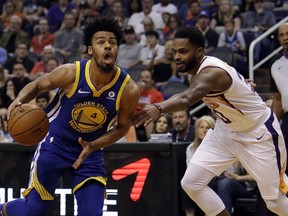 Golden State Warriors guard Quinn Cook (4) drives past Phoenix Suns guard Troy Daniels in the first half during an NBA basketball game, Sunday, April 8, 2018, in Phoenix.