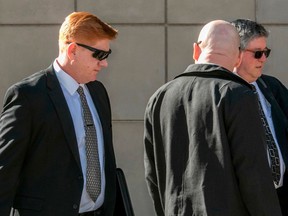 FILE - In this March 21, 2018, file photo, Border Patrol agent Lonnie Swartz, left, makes his way to the U.S. District Court building in downtown Tucson, Ariz., where opening arguments were scheduled to begin in his murder trial. A mistrial was declared Monday, April 23, in the case of Swartz after an Arizona jury acquitted him of a second-degree murder charge in the killing of a teen from Mexico but deadlocked on lesser counts of manslaughter.