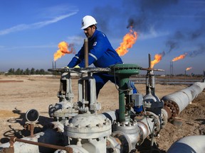 FILE - In this Thursday, Jan. 12, 2017 file photo, an Iraqi worker operates valves in Nihran Bin Omar field north of Basra, Iraq. Emerging from a grueling war with the Islamic State group for more than three years, Iraq plans to open more of its untapped oil and gas resources to foreign developers to boost reserves and to increase sorely needed revenues for post-war construction by offering rights to explore and develop hydrocarbon-rich areas.