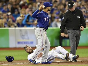 Blue Jays catcher Russell Martin sits on the third base bag after being called out on a tag by Texas Rangers third baseman Isiah Kiner-Falefa during second inning action in Toronto on Friday night. The play was reviewed and Martin was ruled safe.