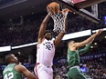 Raptors centre Lucas Nogueira dunks between the Boston Celtics' Al Horford (42) and Jayson Tatum (0) during second half action in Toronto on Wednesday night.