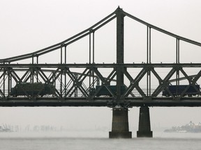 FILE - In this Monday, Nov. 29, 2010, file photo, loaded trucks line up to cross the Friendship Bridge, linking China and North Korea, near the North Korean town of Sinuiju, opposite the Chinese border city of Dandong.  As the U.S.-North Korea summit looms, President Donald Trump's policy of maximum pressure on North Korea may be working - thanks to China. Beijing appears to have gone well beyond U.N. sanctions on its unruly neighbor, reducing its total imports from North Korea in the first two months this year by 78.5 and 86.1 percent in value.