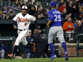 Jonathan Schoop of the Orioles passes Toronto Blue Jays starting pitcher Marco Estrada on his way to home plate for a run on Chris Davis' single in the fourth inning of their game Wednesday night in Baltimore.