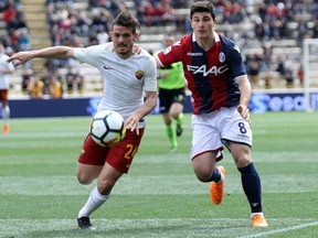 Roma's Alessandro Florenzi, left, and Bologna's Riccardo Orsolini go for the ball during the Serie A soccer match between Bologna and Roma at the Renato Dall'Ara stadium in Bologna, Italy, Saturday, March 31, 2018.