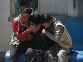 TOPSHOT - Afghan residents weep for their relatives following a suicide bombing attack at the Isteqlal Hospital in Kabul on April 22, 2018.  A suicide bomber killed at least 31 people and wounded dozens outside a voter registration centre in the Afghan capital Kabul on April 22, the health ministry said, in the latest attack on election preparations.